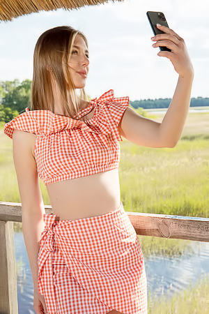 Karianne Bending Over The Railing With A Smile